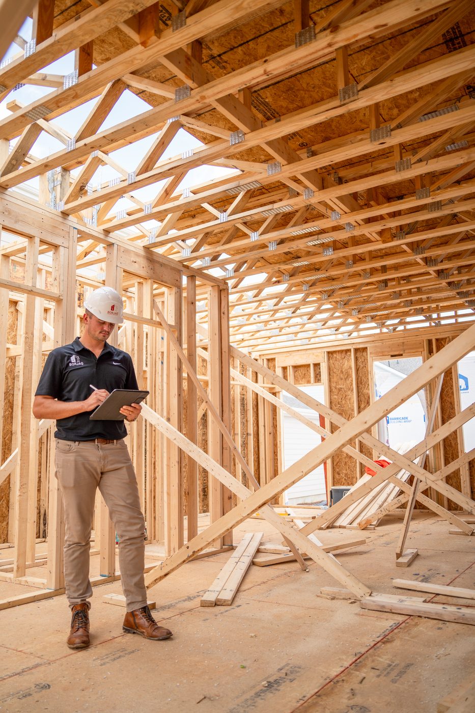Cody standing inside a fully framed home, reviewing the structure