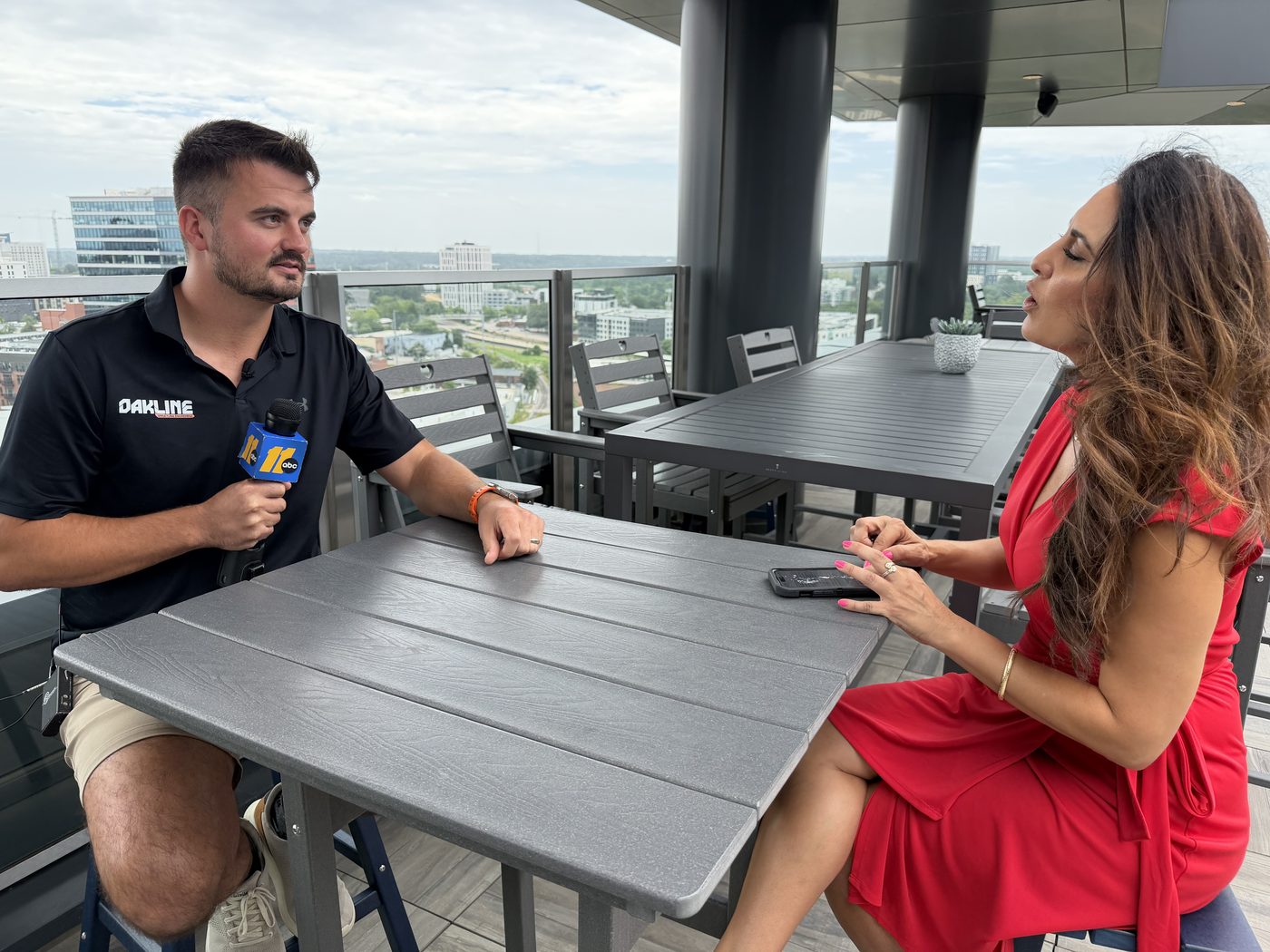Cody Johnston, PE, being interviewed on camera by an ABC11 reporter on a rooftop in downtown Raleigh