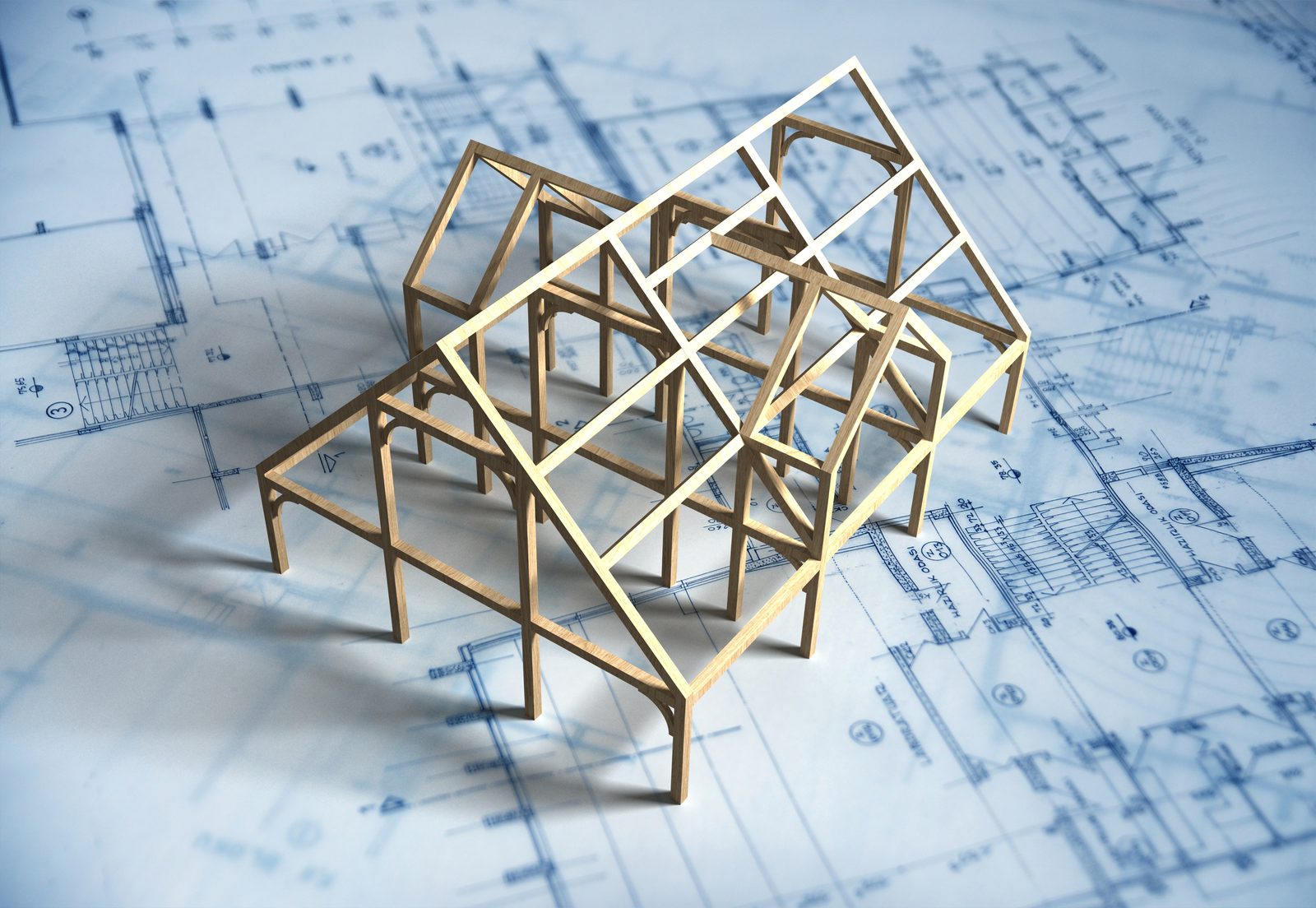 A model house sitting on top of blueprint house plans, ready for structural engineering